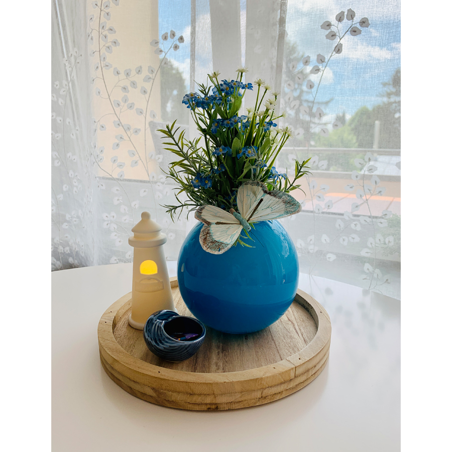 Schöne Vase mir Blumen und Leuchtturm